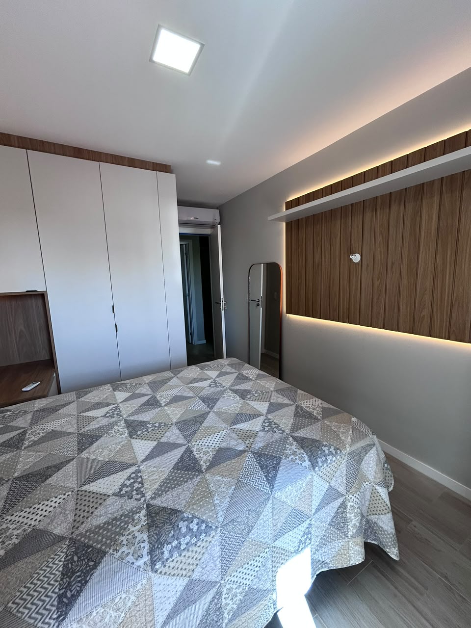 Dormitório planejado com painel iluminado